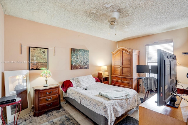 tiled bedroom with a textured ceiling and ceiling fan