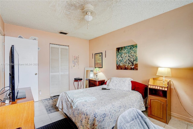 bedroom with a textured ceiling, ceiling fan, and a closet