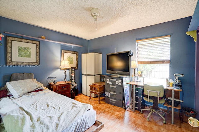 bedroom with light hardwood / wood-style flooring and a textured ceiling