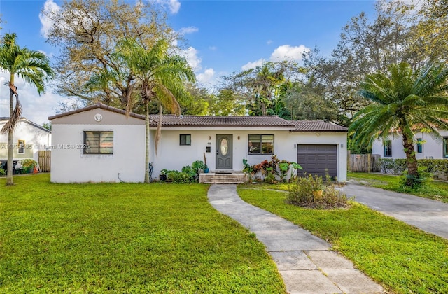 view of front of house with a garage and a front lawn