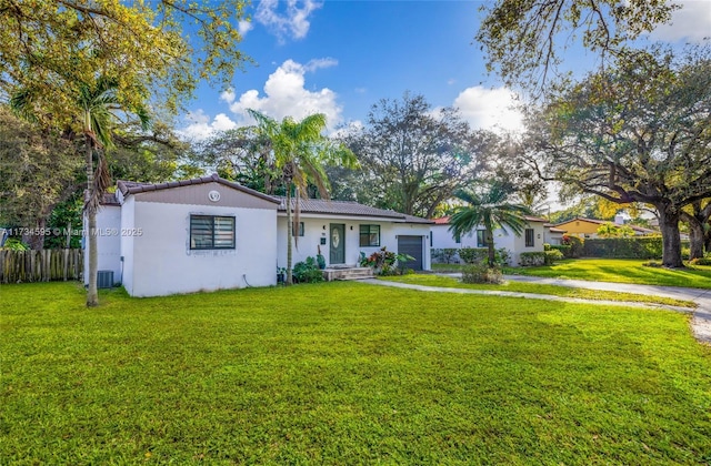 ranch-style home with a garage, a front yard, and central air condition unit