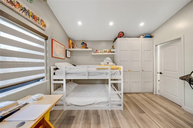 bedroom featuring vaulted ceiling and light wood-type flooring