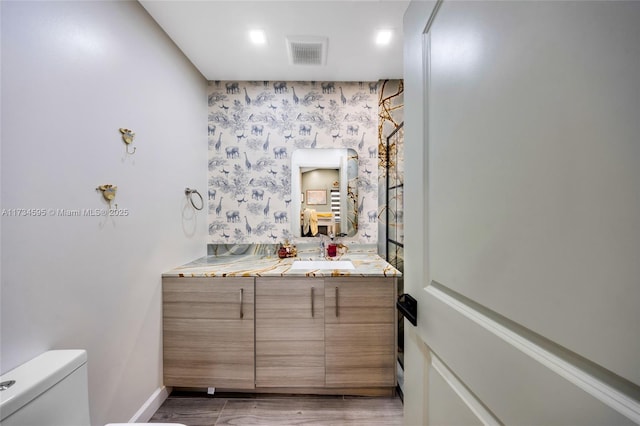 bathroom with vanity, hardwood / wood-style flooring, and toilet