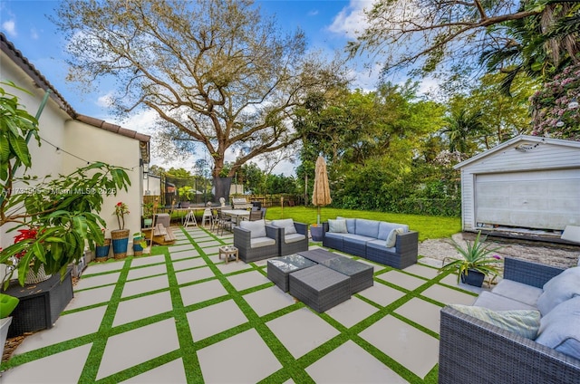 view of patio / terrace with an outbuilding, a garage, an outdoor hangout area, and a trampoline