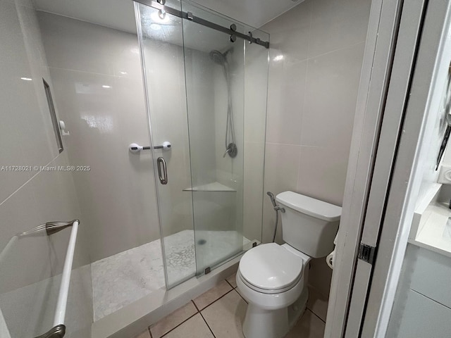 bathroom featuring an enclosed shower, tile patterned flooring, tile walls, and toilet