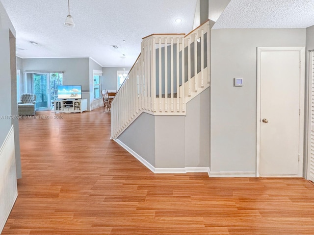 stairs featuring hardwood / wood-style floors and a textured ceiling