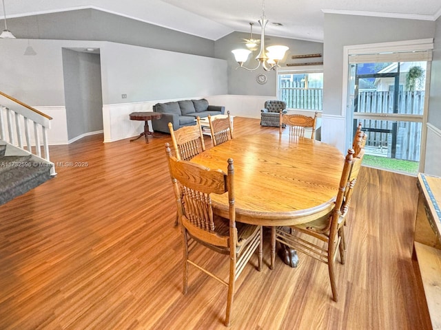 dining area featuring ornamental molding, lofted ceiling, a chandelier, and wood-type flooring