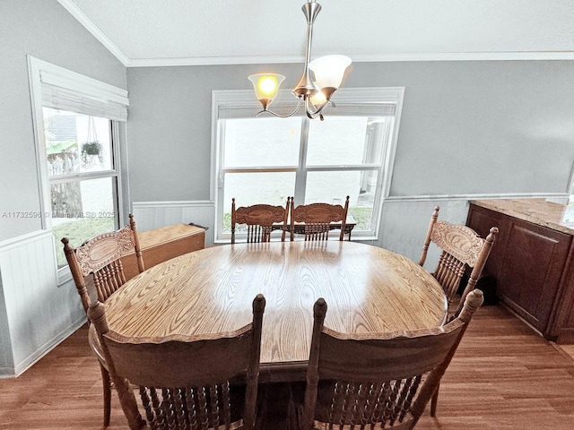 dining area with crown molding, plenty of natural light, hardwood / wood-style floors, and a chandelier