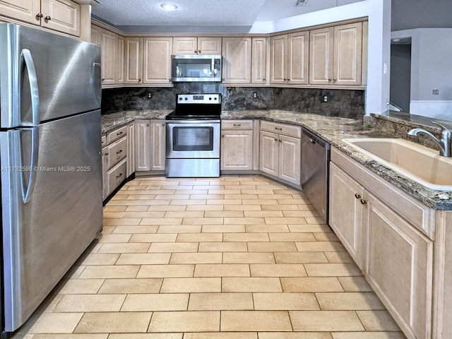 kitchen featuring appliances with stainless steel finishes, tasteful backsplash, sink, kitchen peninsula, and a textured ceiling