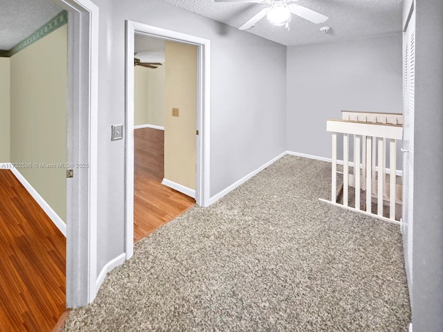 hallway featuring carpet floors and a textured ceiling