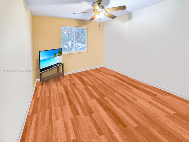 unfurnished living room with ceiling fan, a textured ceiling, and light hardwood / wood-style flooring