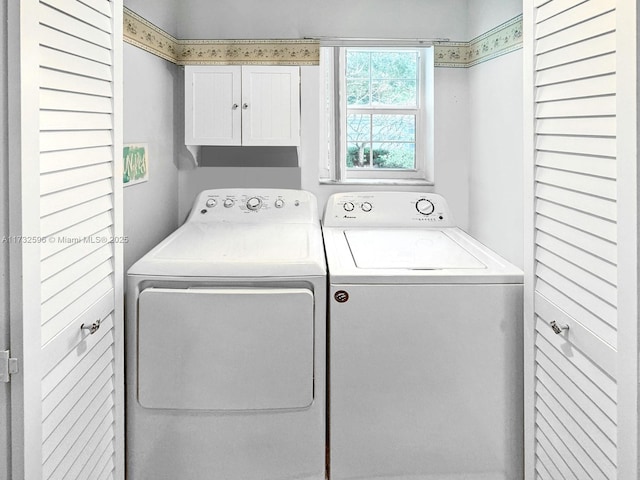 washroom with cabinets and washing machine and dryer