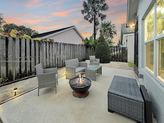 patio terrace at dusk featuring an outdoor living space with a fire pit