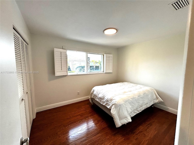 bedroom with dark wood-type flooring