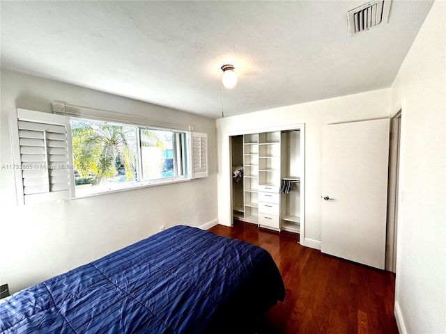 bedroom with dark wood-type flooring and a closet