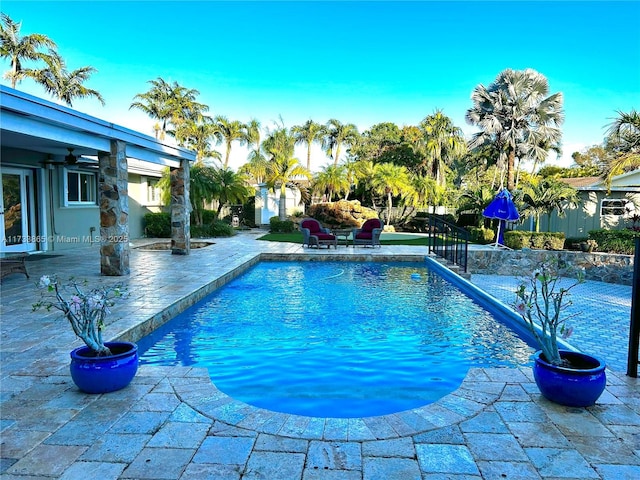 view of pool with ceiling fan and a patio