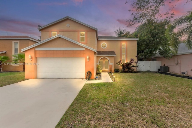 view of front facade with cooling unit, a garage, and a lawn