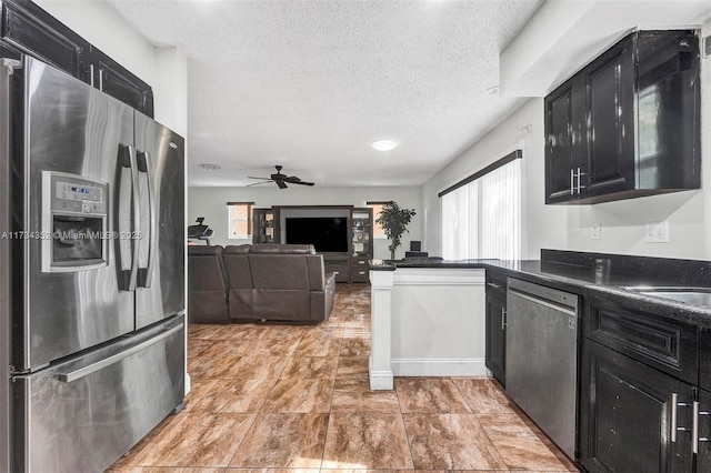 9500 Atlantic St, Miramar, FL 33025 - kitchen featuring appliances with stainless steel finishes, dark cabinets, dark countertops, ceiling fan, and a textured ceiling