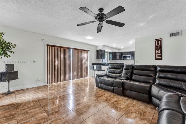 living room with a textured ceiling and ceiling fan