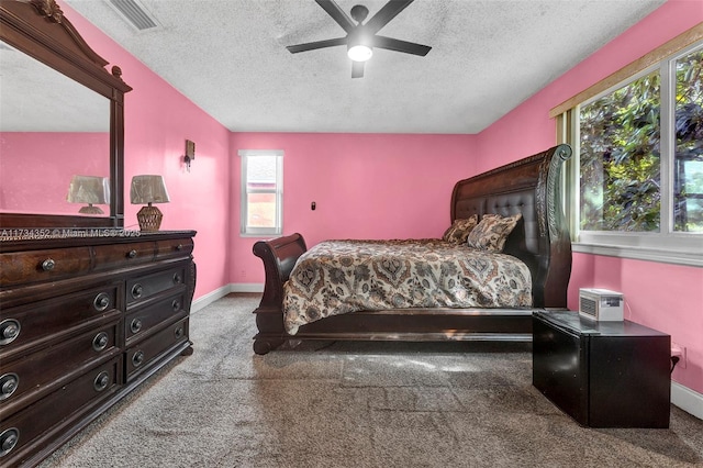 carpeted bedroom with ceiling fan and a textured ceiling