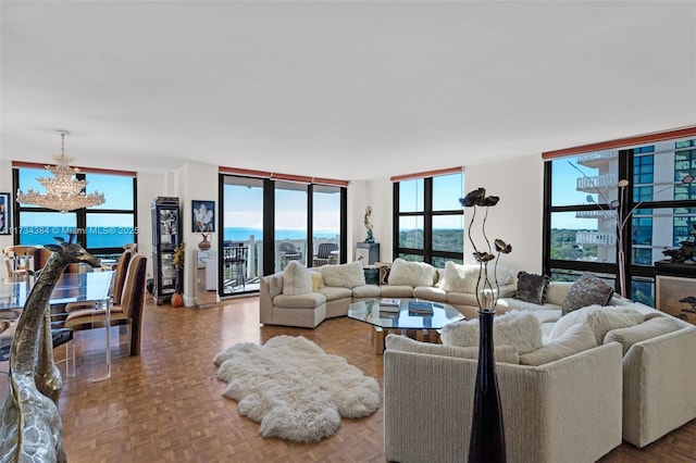 living room featuring parquet floors, expansive windows, a chandelier, and a water view