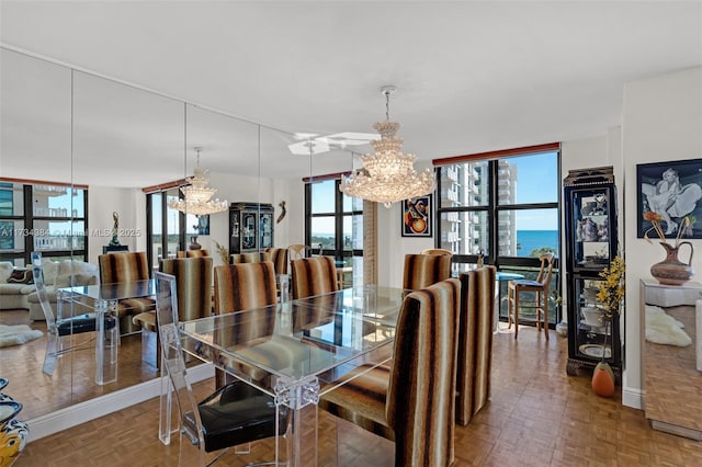 dining room with a notable chandelier, parquet floors, and a water view