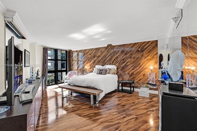 bedroom with hardwood / wood-style flooring, ornamental molding, expansive windows, and wood walls