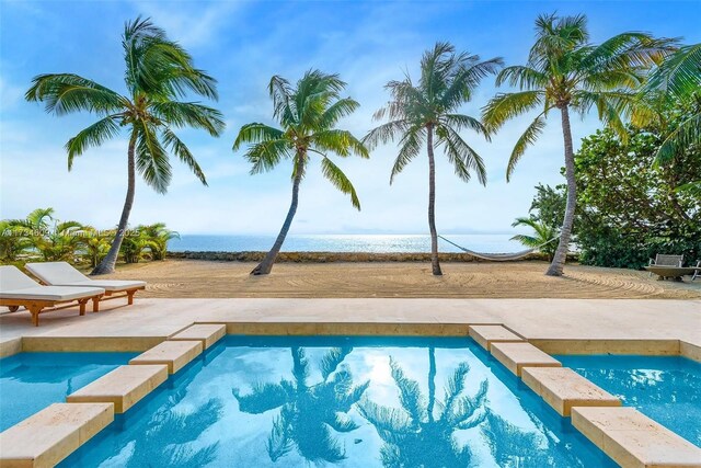 view of swimming pool with a patio area and a water view