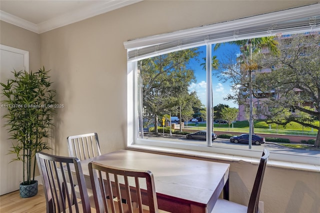 dining room with a wealth of natural light, light hardwood / wood-style flooring, and ornamental molding