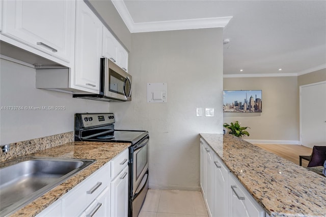 kitchen featuring sink, light stone counters, ornamental molding, appliances with stainless steel finishes, and white cabinets