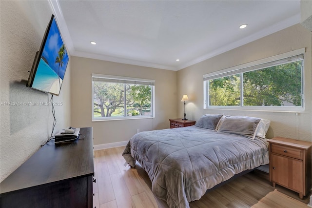 bedroom with ornamental molding and light wood-type flooring