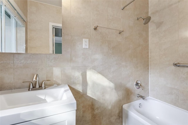 bathroom with tiled shower / bath combo and vanity