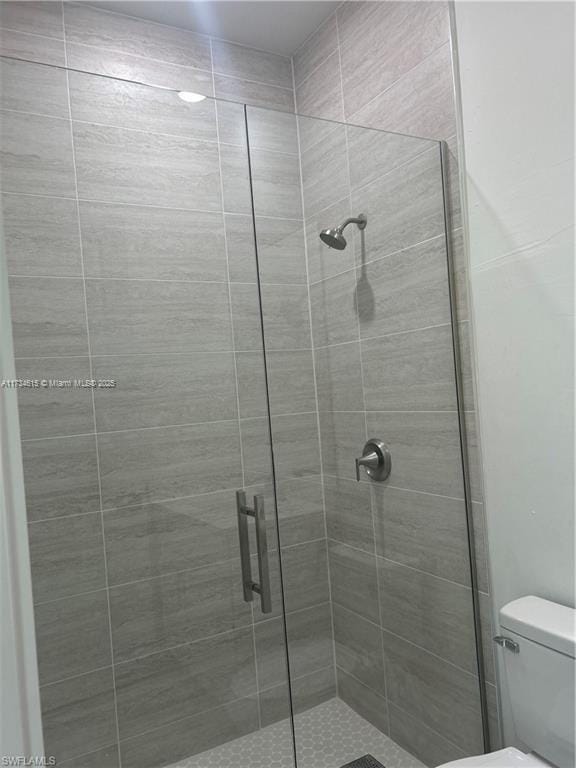 bathroom with an enclosed shower and toilet