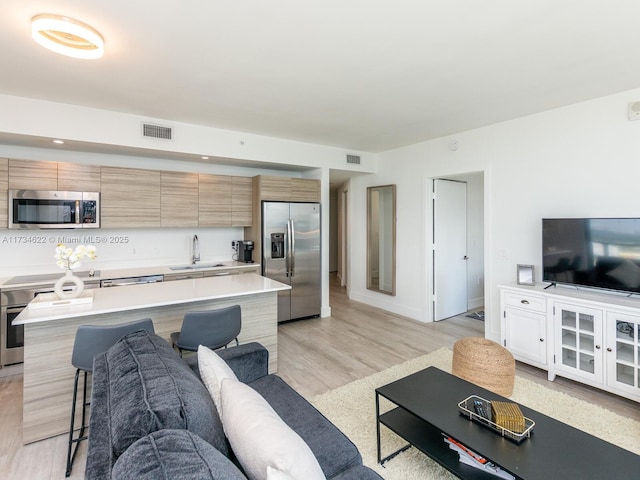 living room with sink and light wood-type flooring