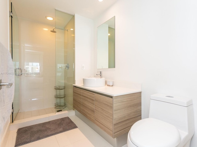 bathroom with a shower with door, vanity, tile patterned floors, and toilet