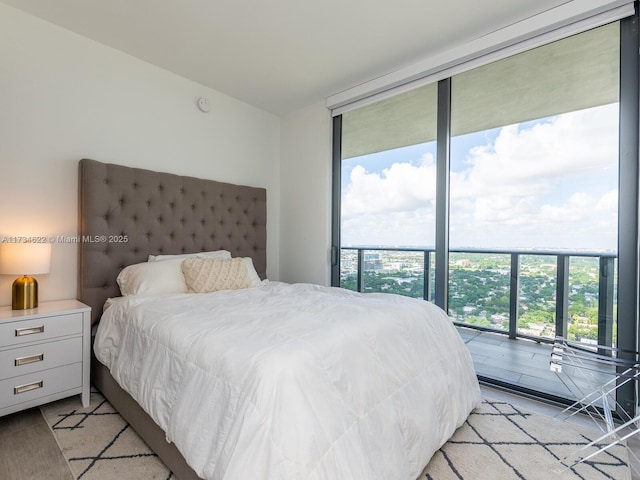 bedroom featuring a wall of windows, access to exterior, and multiple windows