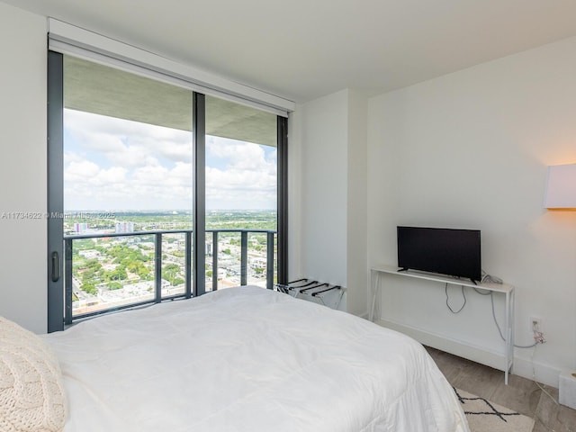 bedroom with hardwood / wood-style flooring and floor to ceiling windows