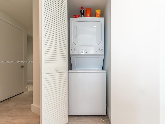 washroom with stacked washer / dryer and light wood-type flooring