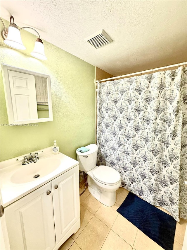 bathroom with vanity, tile patterned floors, a textured ceiling, and toilet