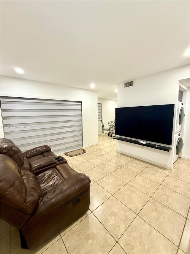 living room featuring light tile patterned flooring and stacked washer and clothes dryer