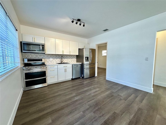 kitchen featuring white cabinetry, appliances with stainless steel finishes, sink, and backsplash