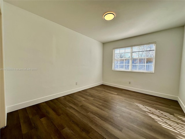 spare room with dark wood-type flooring