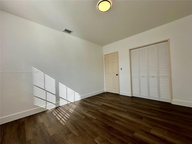 unfurnished bedroom featuring dark hardwood / wood-style floors and a closet