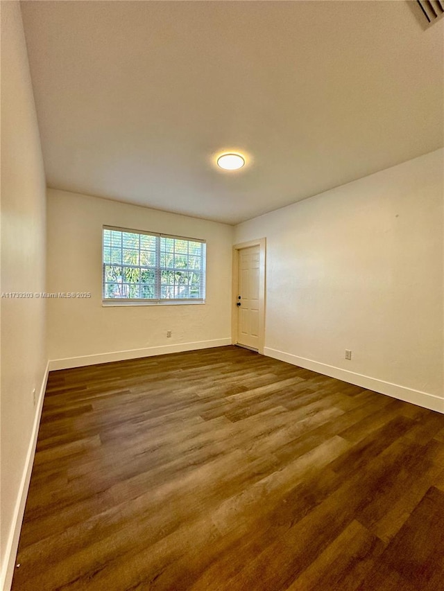 spare room with dark hardwood / wood-style floors