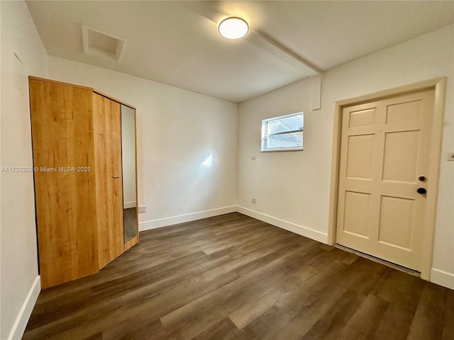 unfurnished bedroom featuring dark hardwood / wood-style flooring and a closet