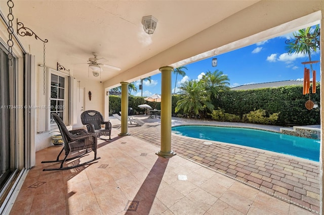 view of swimming pool featuring ceiling fan and a patio