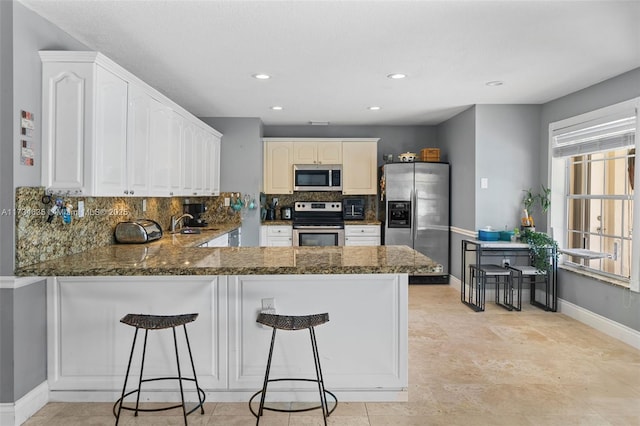 kitchen featuring a breakfast bar, appliances with stainless steel finishes, and kitchen peninsula