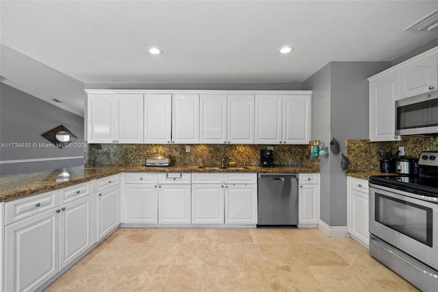 kitchen featuring white cabinetry, appliances with stainless steel finishes, and dark stone countertops