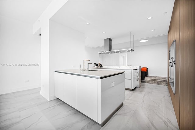 kitchen featuring extractor fan, sink, a center island, and white cabinets