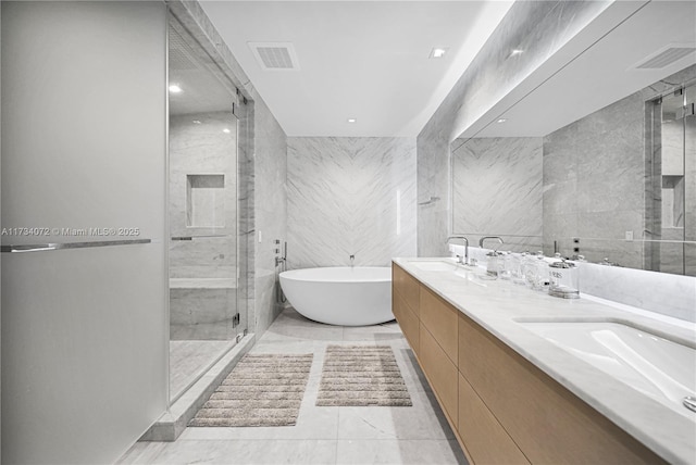 bathroom featuring independent shower and bath, vanity, and tile walls